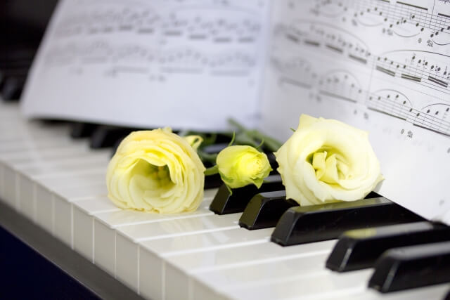 ピアノの鍵盤上の楽譜と花