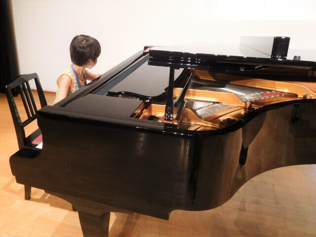 グランドピアノを弾く子供